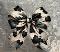 Cow Print Bow - large black and white cow print ribbon bow with detailed ribbon folds and curled tails