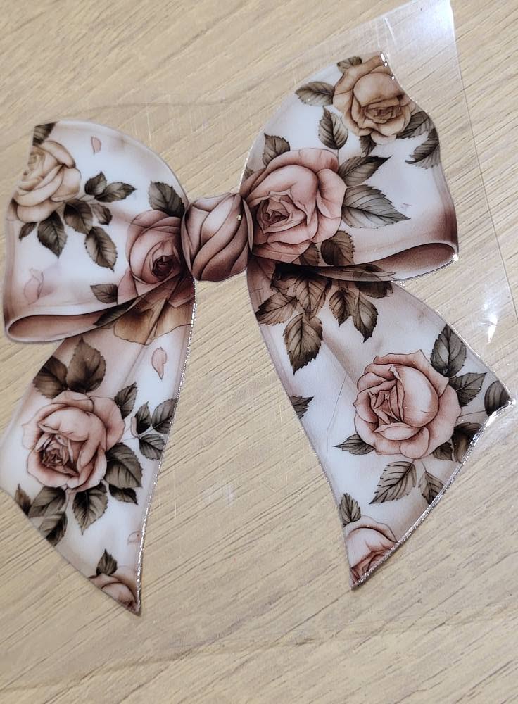 Vintage Rose Bow - romantic bow covered in dusty pink roses and dark green leaves on soft cream background with gold glitter edge