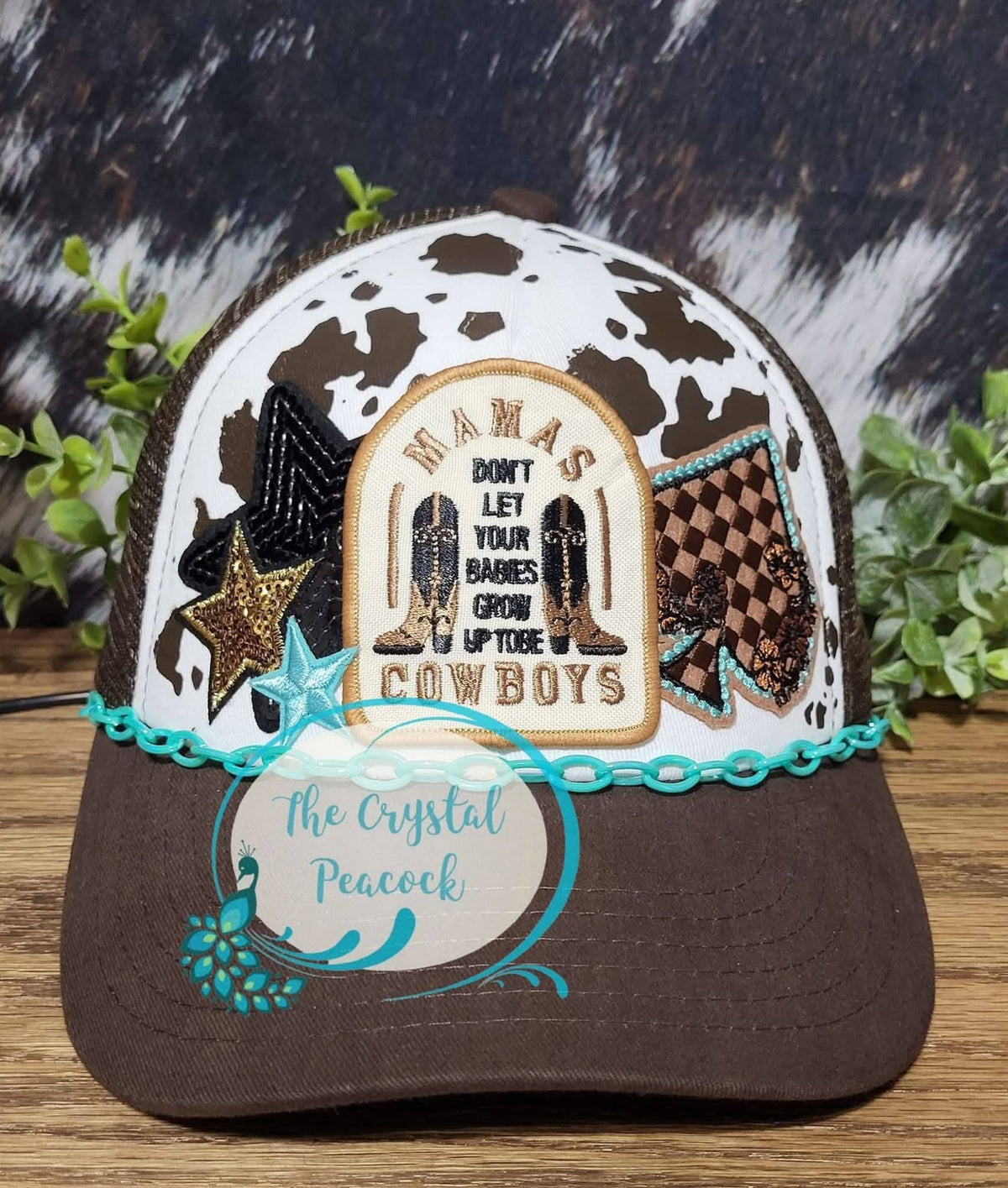 Mamas Don't Let Your Babies Grow Up To Be Cowboys Trucker Hat with cow print and embroidered patches